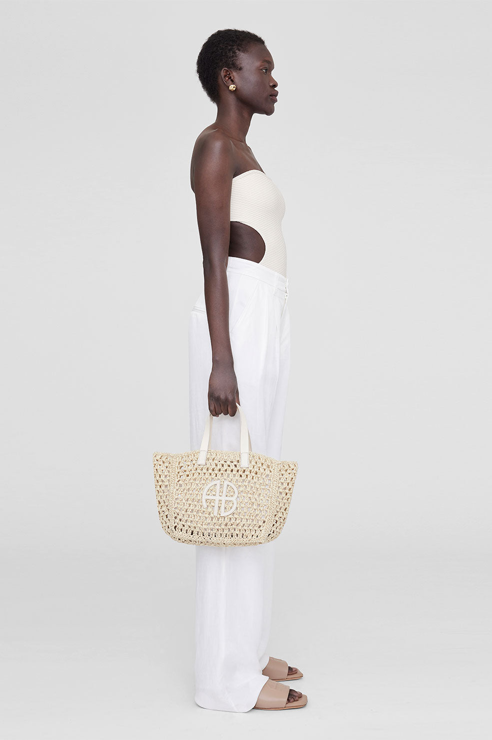 The Small Rio Tote by Anine Bing is a vacation essential made from an  unlined woven seagrass material. This seasonal style features two…